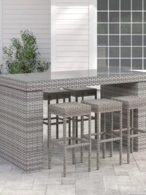 Long outdoor wicker bar table with matching bar stools in a modern patio setting, designed by Outadore Space