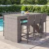 Outdoor wicker bar table with matching stools placed on a modern patio, durable outdoor furniture by Outadore Space