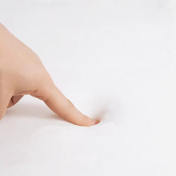 Soft outdoor cushion showing high-density foam comfort as a finger presses into the fabric, used in Outadore Space furniture