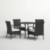 Outdoor rattan dining set with cushioned chairs and round table on a patio, crafted by Outadore Space