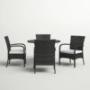 Outdoor rattan dining set with cushioned chairs and round table on a patio, crafted by Outadore Space