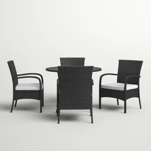 Outdoor rattan dining set with cushioned chairs and round table on a patio, crafted by Outadore Space